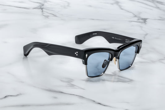 Black sunglasses with blue lenses on a marble surface