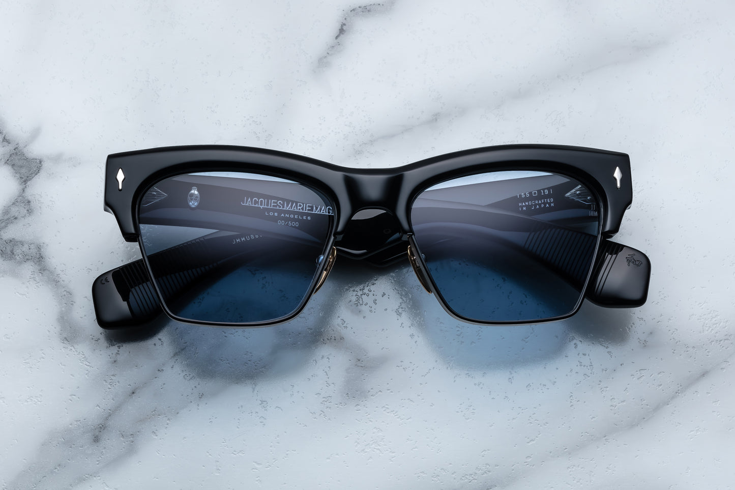 Black sunglasses with blue lenses on a marble surface