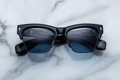 Black sunglasses with blue lenses on a marble surface